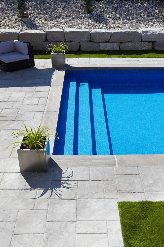 На фото: большой естественный, прямоугольный бассейн на заднем дворе в стиле модернизм с мощением клинкерной брусчаткой с