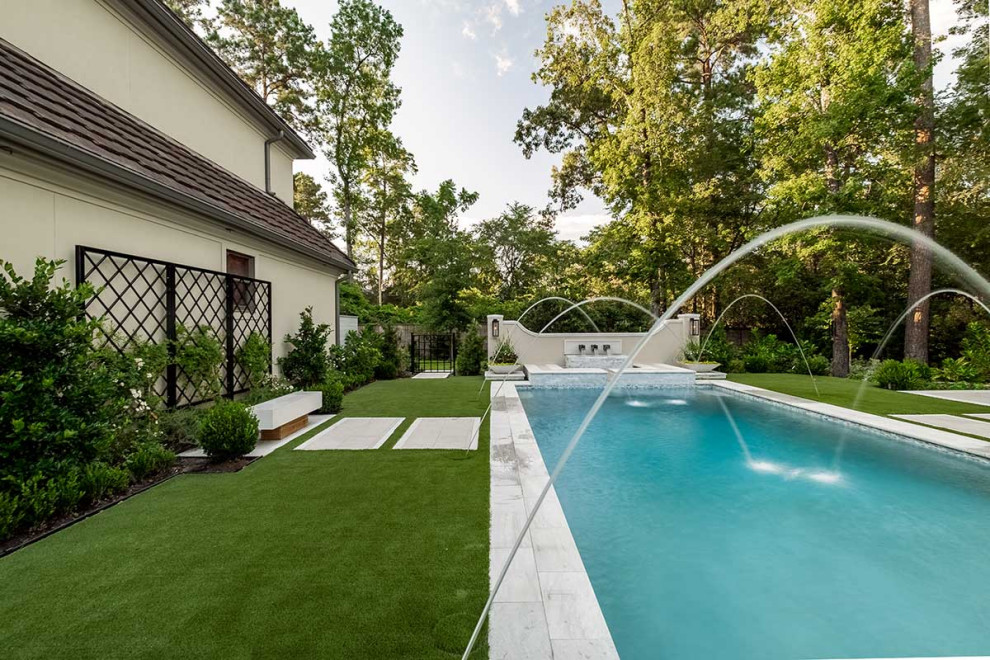 Свежая идея для дизайна: большой прямоугольный бассейн на заднем дворе с покрытием из каменной брусчатки - отличное фото интерьера