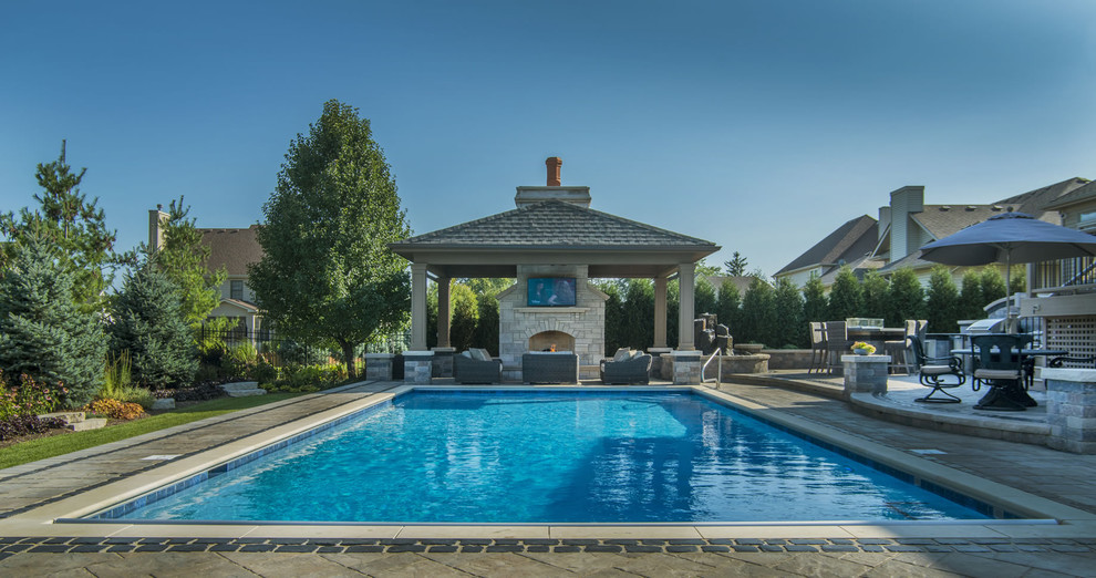 Idéer för att renovera en mellanstor rektangulär pool på baksidan av huset, med poolhus och naturstensplattor