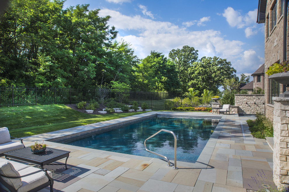 На фото: прямоугольный бассейн среднего размера на заднем дворе в классическом стиле с джакузи и покрытием из каменной брусчатки с