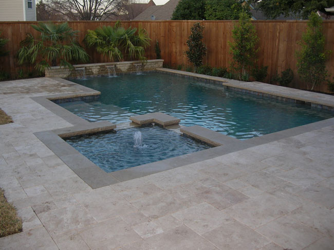 Photo of a medium sized contemporary back rectangular lengths hot tub in Dallas with natural stone paving.