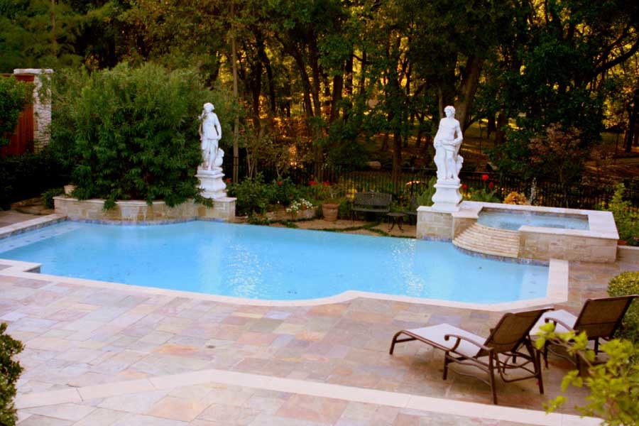 Aménagement d'une piscine arrière et à débordement éclectique rectangle et de taille moyenne avec un bain bouillonnant et des pavés en pierre naturelle.