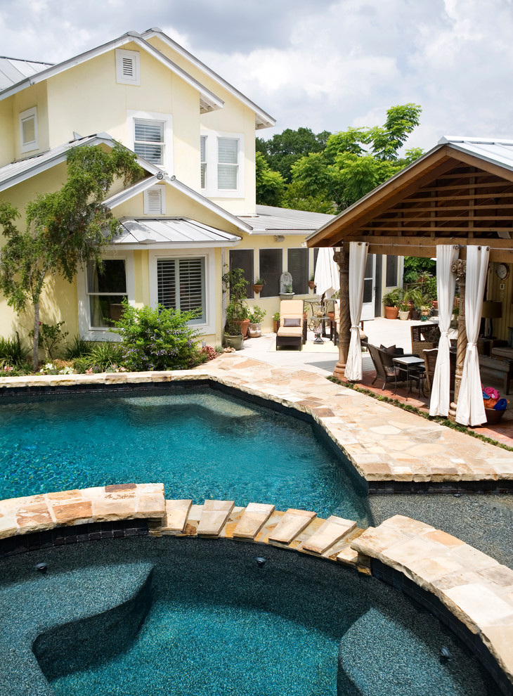 Example of a large classic backyard stone and custom-shaped natural pool house design in Austin