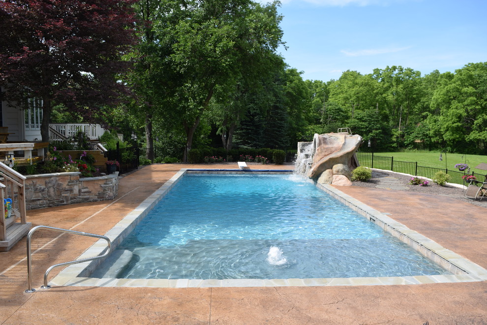 Diseño de piscina con fuente natural contemporánea grande rectangular en patio trasero
