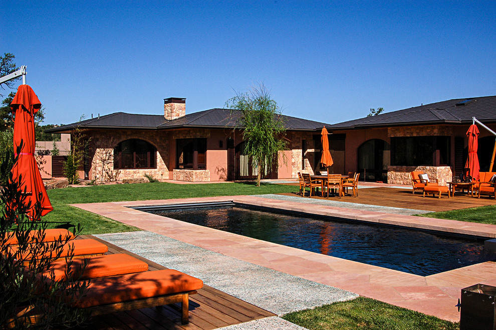 Ejemplo de piscina alargada contemporánea de tamaño medio rectangular en patio trasero con adoquines de piedra natural