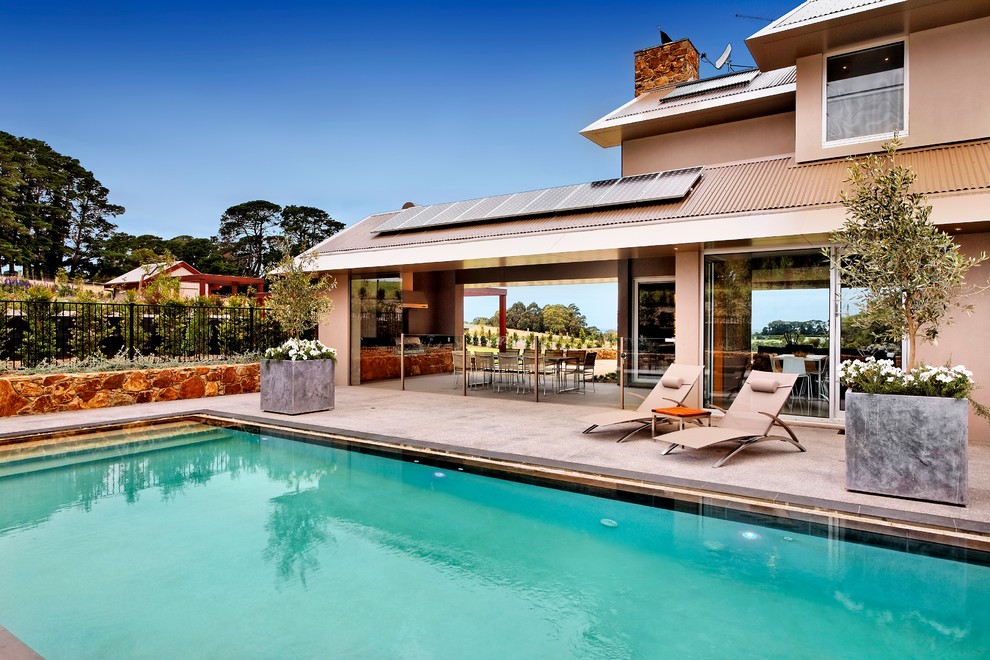 Immagine di una piscina naturale minimal rettangolare di medie dimensioni e dietro casa con lastre di cemento