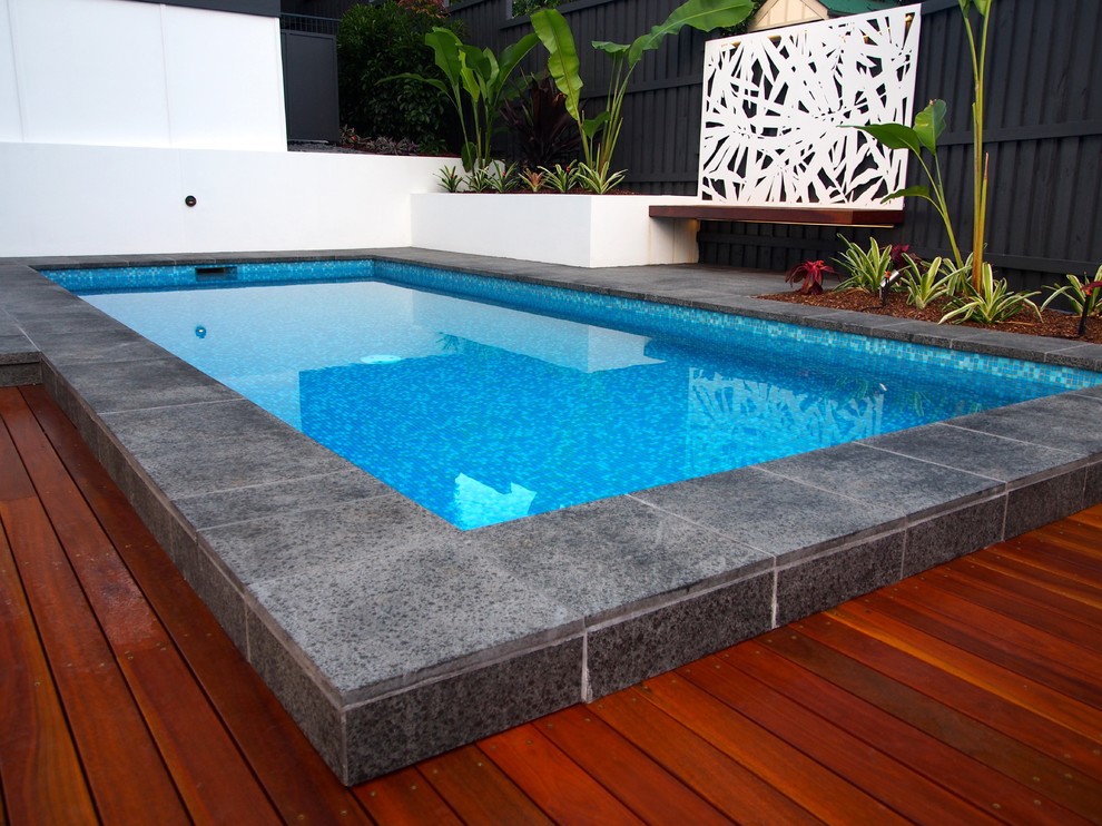 Пример оригинального дизайна: маленький прямоугольный бассейн в стиле модернизм с покрытием из каменной брусчатки для на участке и в саду