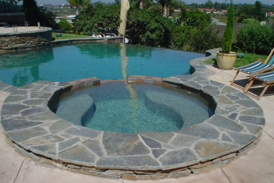 Modelo de piscinas y jacuzzis infinitos clásicos de tamaño medio a medida en patio trasero con losas de hormigón