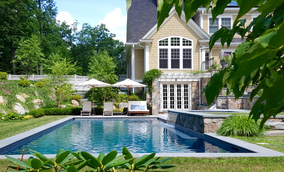 Imagen de piscina con fuente clásica renovada rectangular en patio trasero con suelo de hormigón estampado