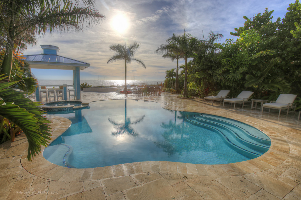 Esempio di una piscina naturale stile marino personalizzata di medie dimensioni e dietro casa con fontane e pavimentazioni in mattoni
