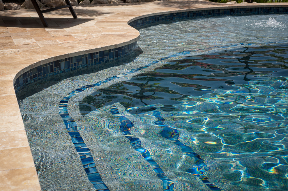 Стильный дизайн: бассейн среднего размера, произвольной формы на заднем дворе в морском стиле с джакузи и покрытием из каменной брусчатки - последний тренд