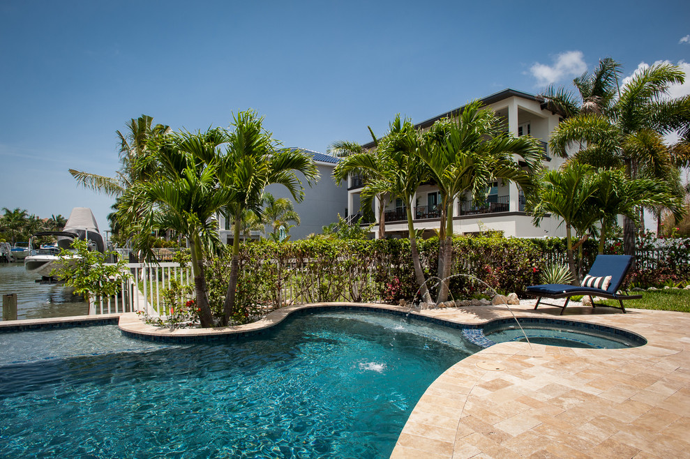 Idéer för mellanstora tropiska anpassad pooler på baksidan av huset, med spabad och naturstensplattor