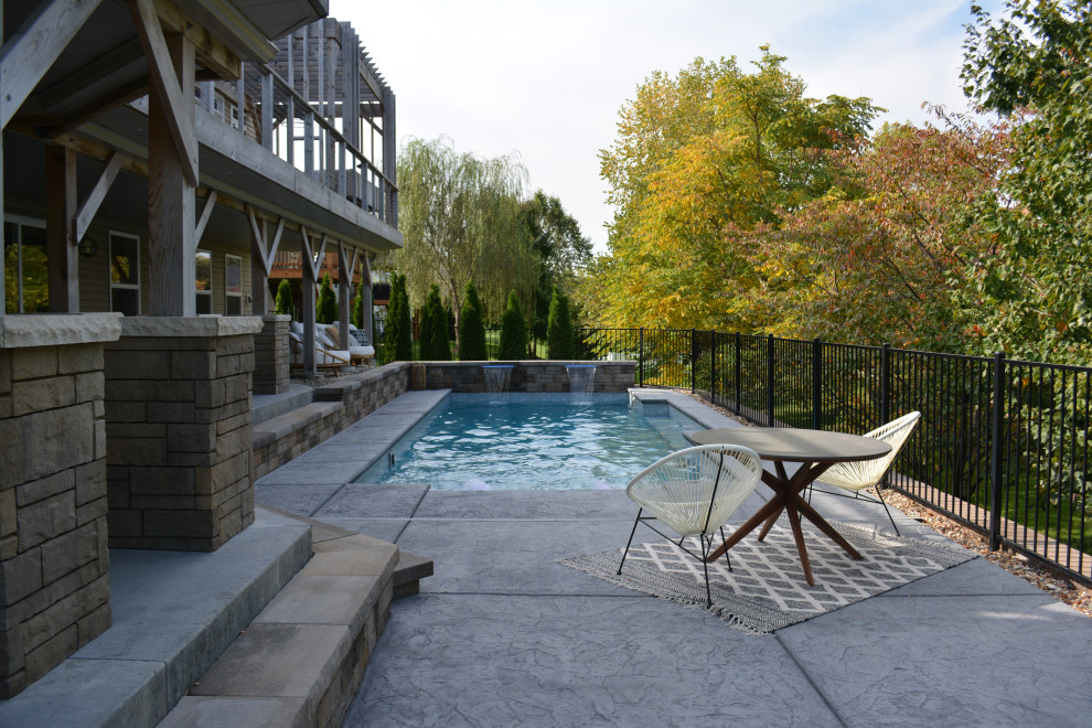 Immagine di una grande piscina naturale moderna rettangolare dietro casa con paesaggistica bordo piscina e cemento stampato