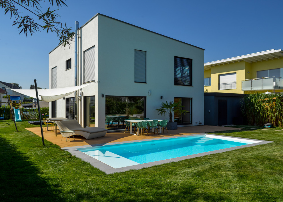 Imagen de piscina moderna de tamaño medio rectangular en patio lateral con losas de hormigón