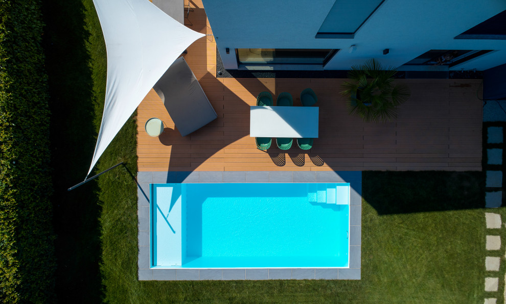 Foto di una piscina minimalista rettangolare di medie dimensioni e nel cortile laterale con lastre di cemento