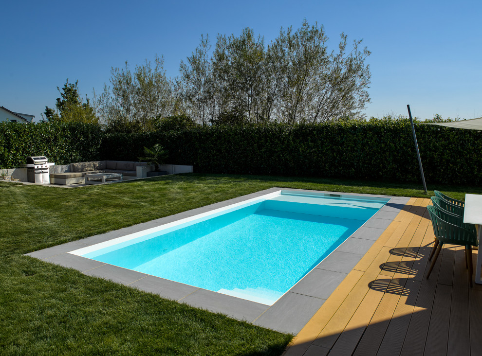 Пример оригинального дизайна: прямоугольный бассейн среднего размера на боковом дворе в стиле модернизм с покрытием из бетонных плит