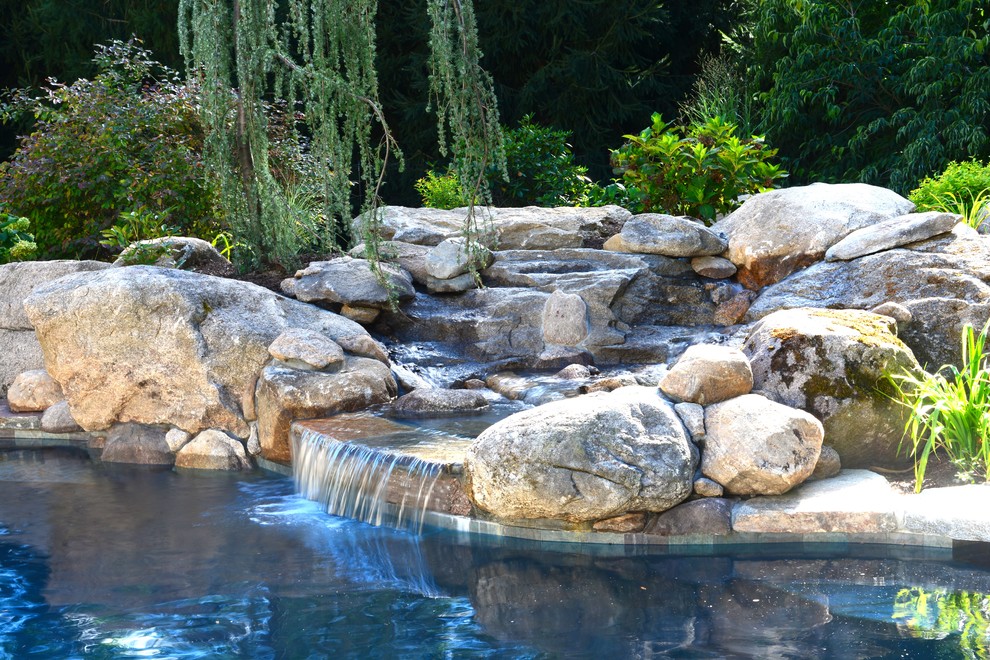 Cette photo montre une grande piscine naturelle et arrière montagne sur mesure avec un bain bouillonnant et des pavés en pierre naturelle.