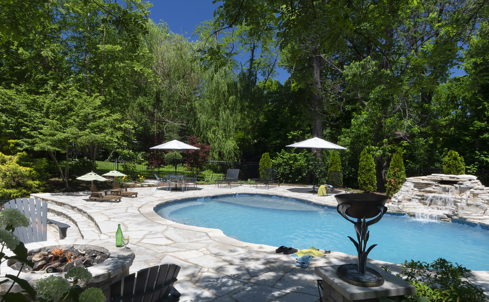 Foto di una grande piscina naturale tradizionale personalizzata dietro casa con fontane e pavimentazioni in pietra naturale