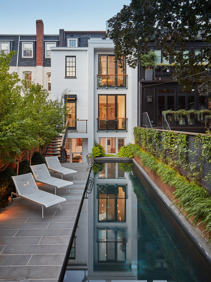 Esempio di una piscina monocorsia minimalista rettangolare dietro casa con pavimentazioni in cemento