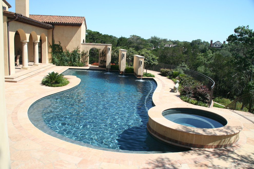 Pool fountain - mediterranean backyard stone pool fountain idea in Houston