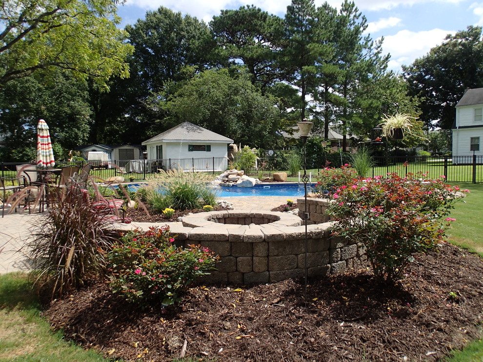 Foto de piscina con fuente contemporánea de tamaño medio a medida en patio trasero con adoquines de piedra natural