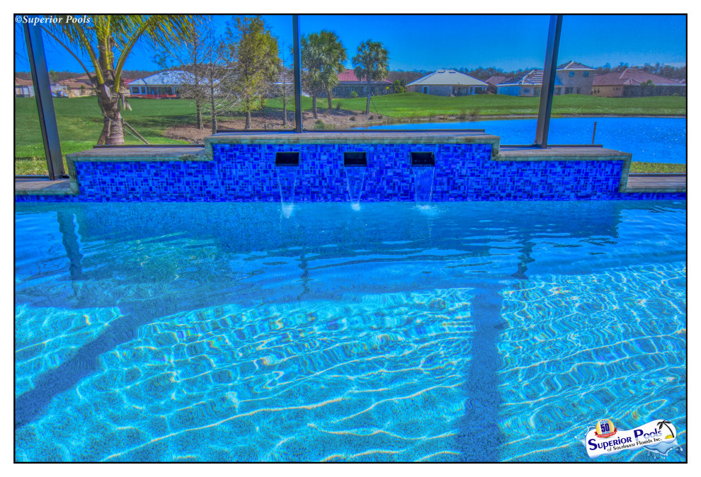 This is an example of a medium sized contemporary back rectangular lengths swimming pool in Tampa with a pool house and brick paving.