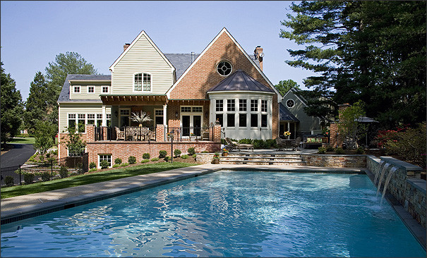 Diseño de piscina con fuente alargada clásica grande rectangular en patio trasero con adoquines de hormigón