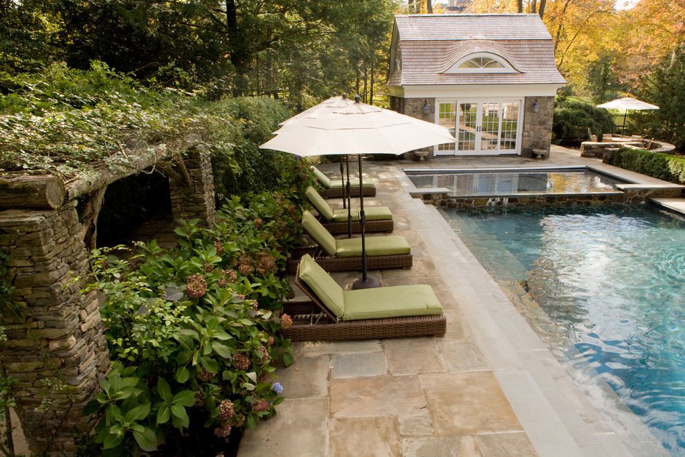 Immagine di una piscina tradizionale rettangolare con pavimentazioni in pietra naturale