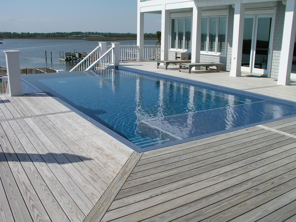 Immagine di una piscina a sfioro infinito stile marino personalizzata con pedane