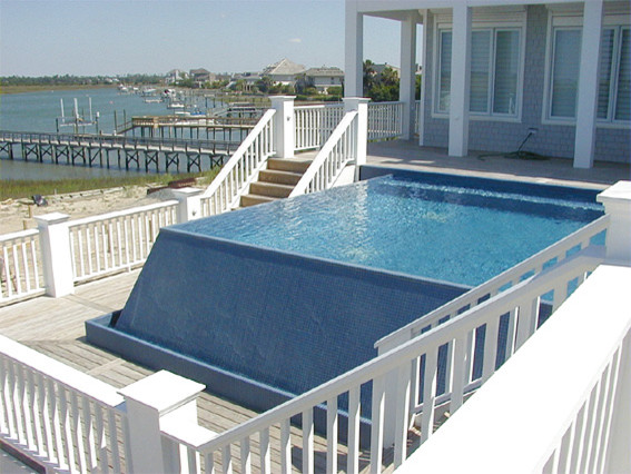 Photo of a contemporary rectangular infinity swimming pool in Other with decking.