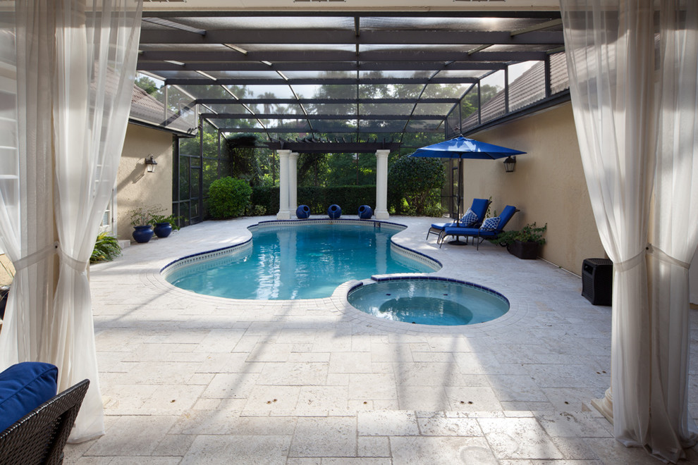 Aménagement d'une piscine naturelle et arrière méditerranéenne en forme de haricot de taille moyenne avec des pavés en pierre naturelle et un bain bouillonnant.