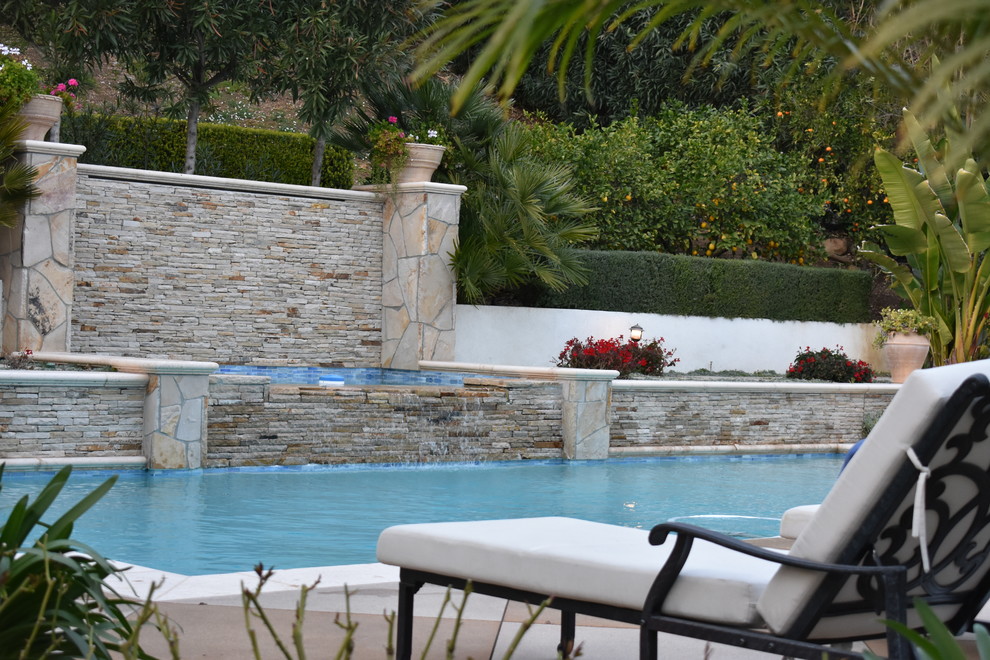Ispirazione per una piscina monocorsia mediterranea personalizzata di medie dimensioni e dietro casa con una vasca idromassaggio e lastre di cemento