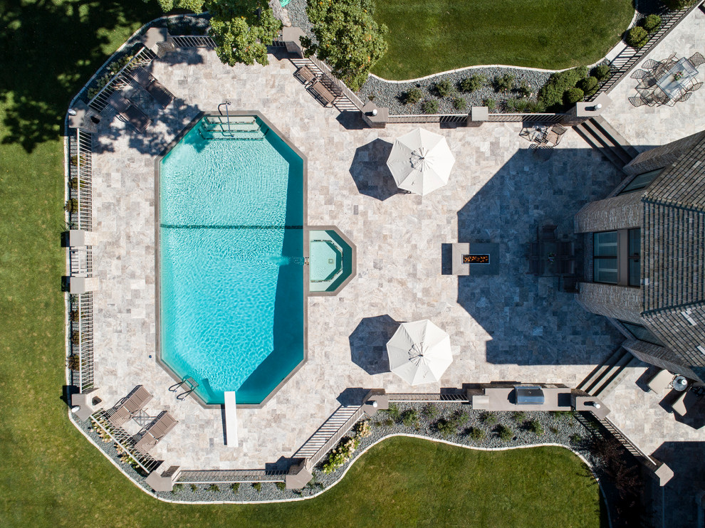 Ispirazione per una grande piscina design personalizzata dietro casa con una vasca idromassaggio e pavimentazioni in pietra naturale
