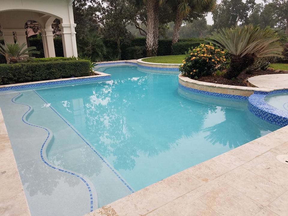 Foto di una grande piscina naturale mediterranea personalizzata dietro casa con una vasca idromassaggio e cemento stampato