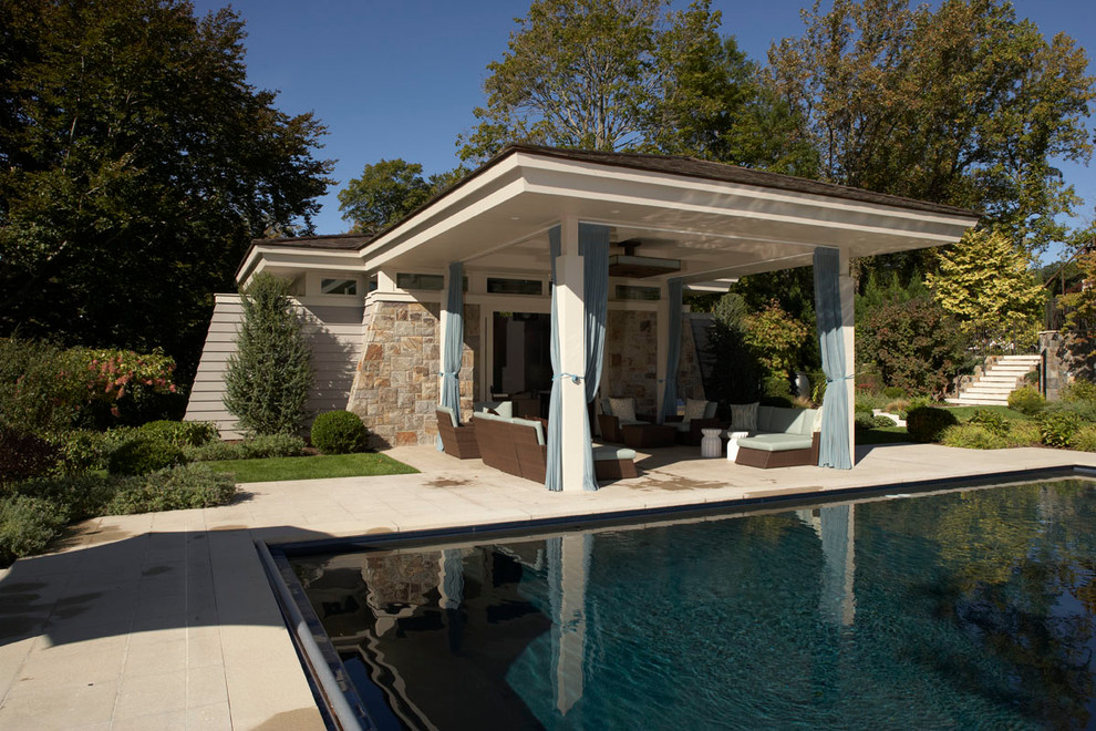 Diseño de casa de la piscina y piscina alargada tradicional extra grande rectangular en patio trasero con losas de hormigón
