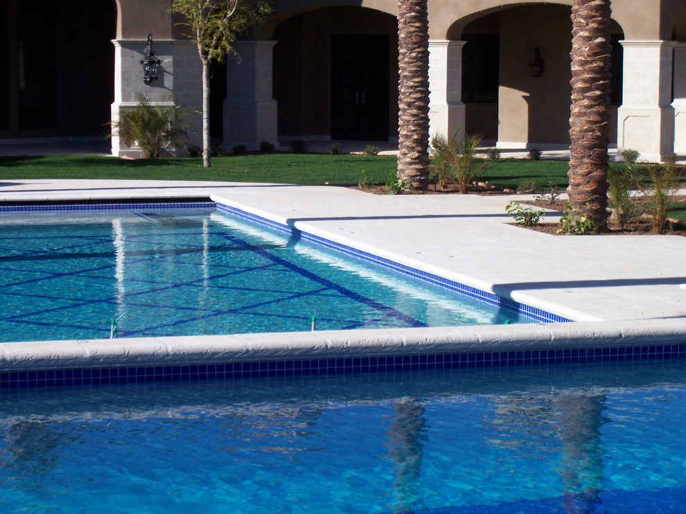 Imagen de piscina mediterránea rectangular en patio trasero con losas de hormigón