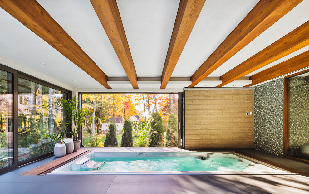 Modelo de piscina contemporánea de tamaño medio rectangular en patio trasero con suelo de baldosas