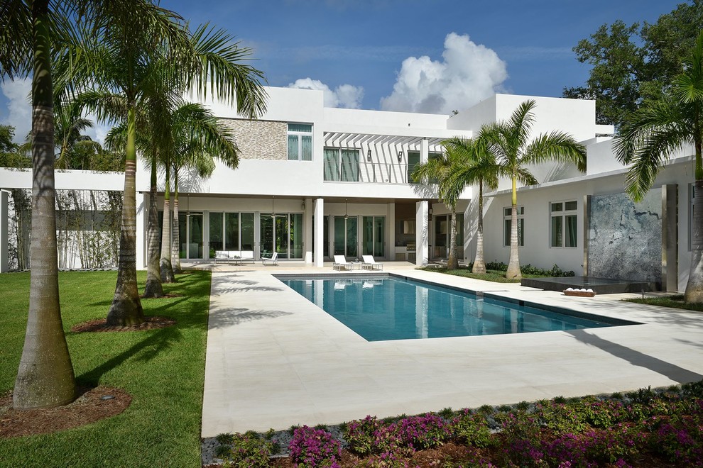 Moderner Pool hinter dem Haus in rechteckiger Form mit Betonplatten in Miami