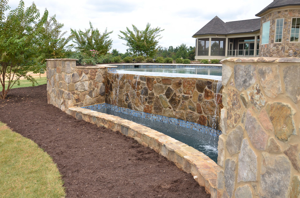 Pool fountain - traditional backyard custom-shaped pool fountain idea in New Orleans