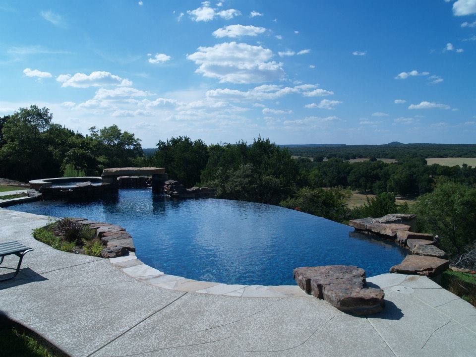 Großer Mediterraner Pool in Nierenform mit Wasserspiel und Stempelbeton in Austin