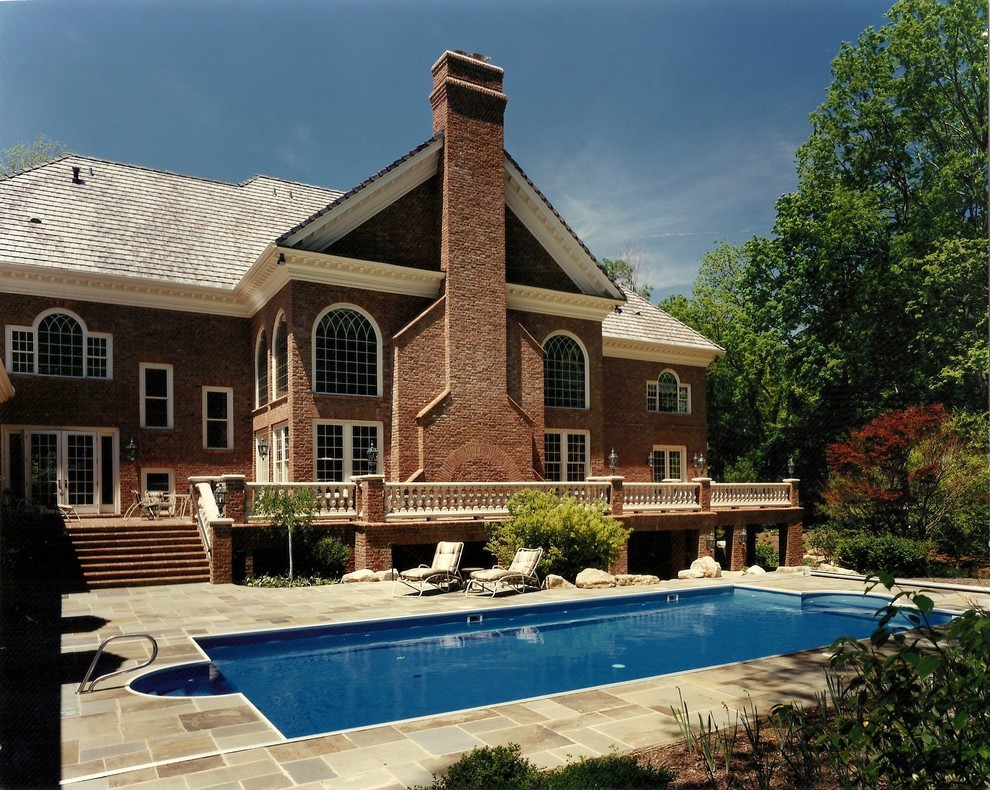 Example of a huge classic backyard stone and rectangular pool design in Other