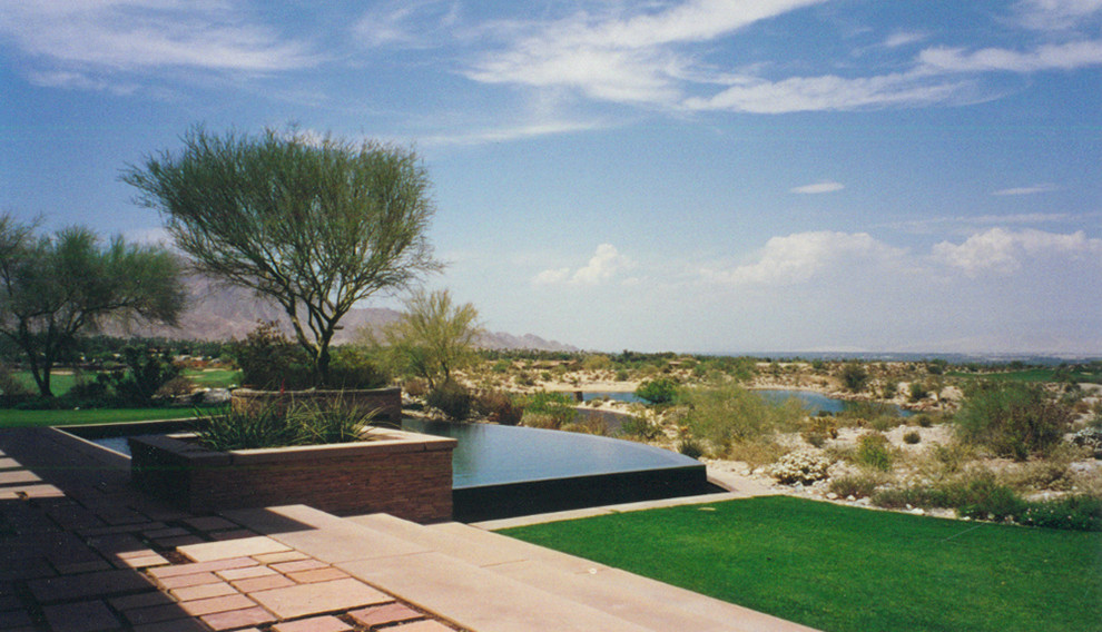 На фото: большой прямоугольный бассейн-инфинити на заднем дворе в современном стиле с домиком у бассейна
