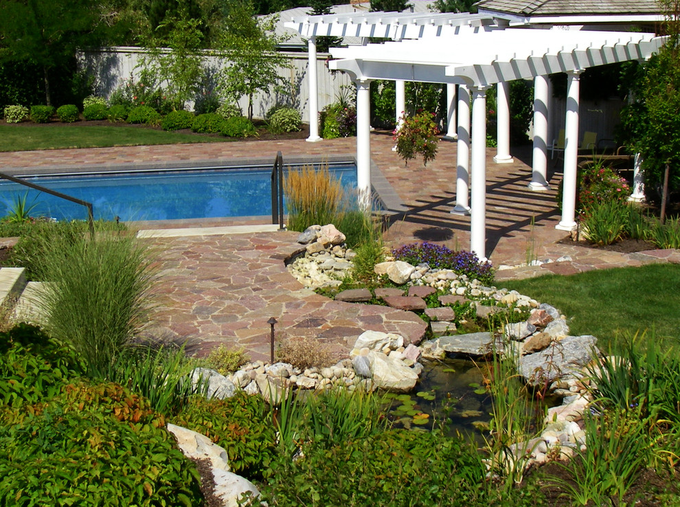 Foto de casa de la piscina y piscina alargada clásica de tamaño medio rectangular en patio trasero con suelo de baldosas