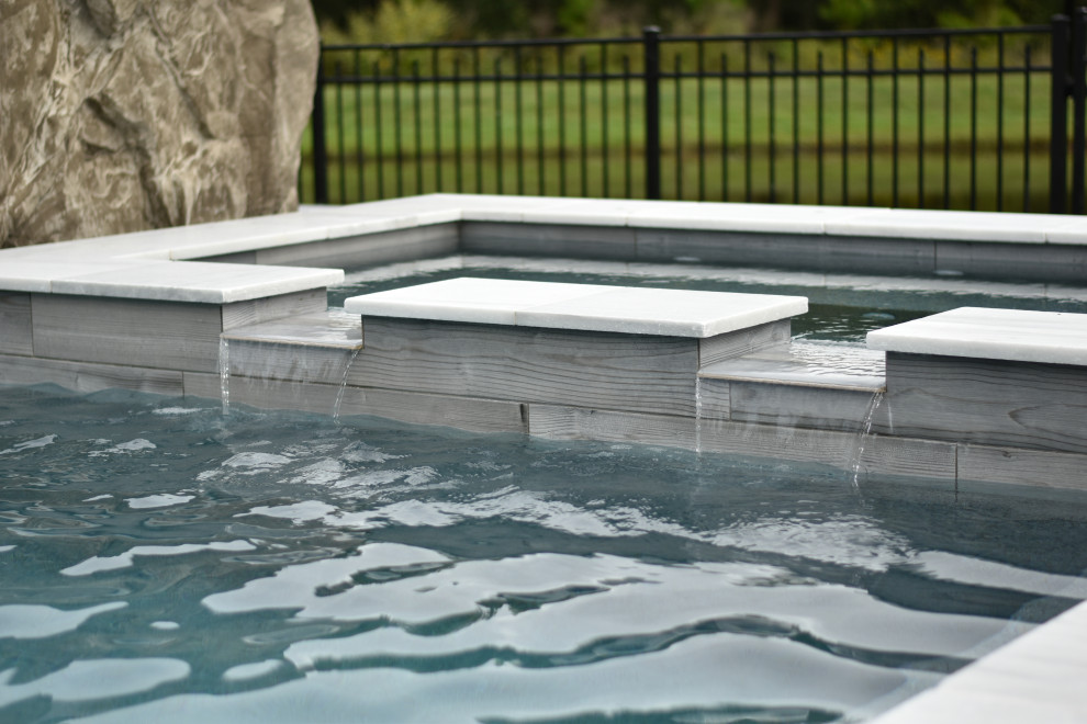 Idées déco pour une grande piscine arrière contemporaine sur mesure avec un toboggan et des pavés en pierre naturelle.