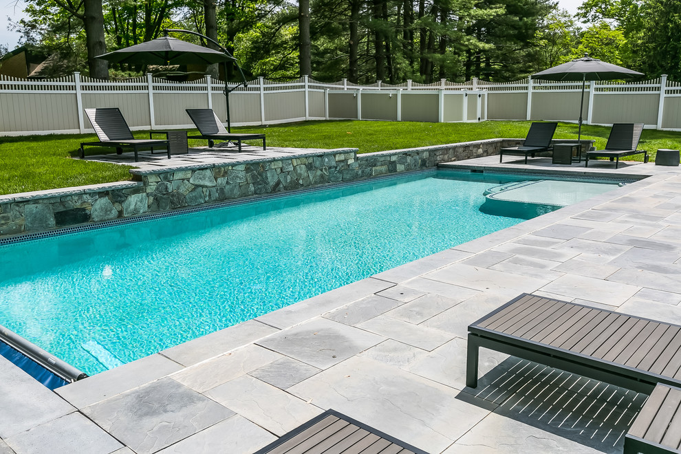 На фото: спортивный, прямоугольный бассейн среднего размера на заднем дворе в стиле неоклассика (современная классика) с покрытием из каменной брусчатки с