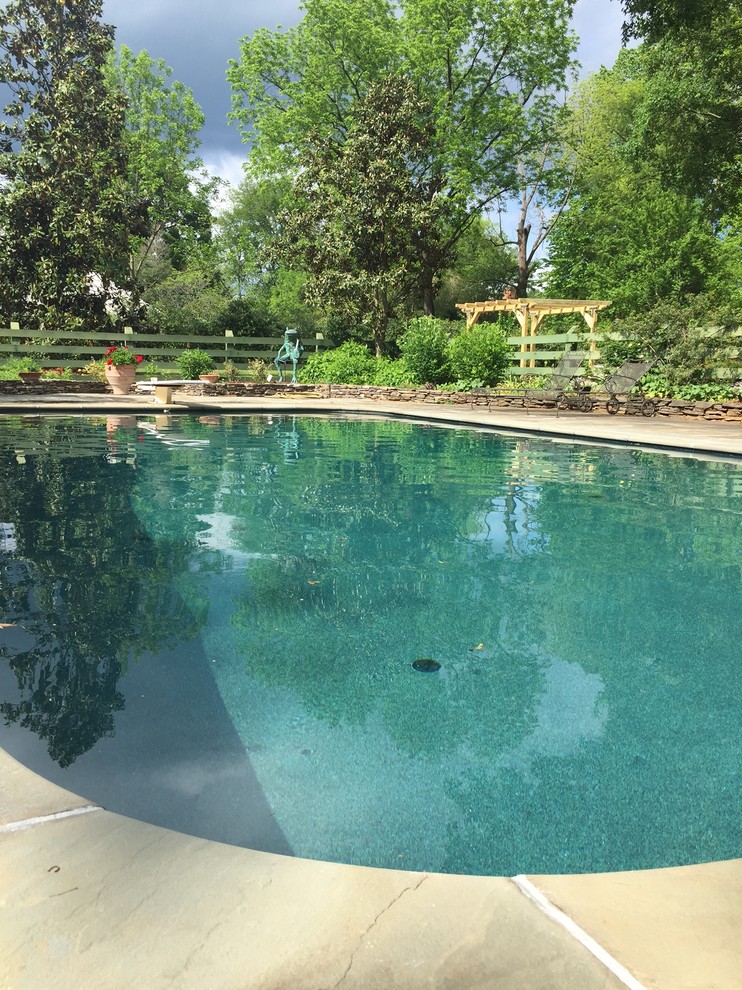 Mittelgroßer Klassischer Schwimmteich hinter dem Haus in rechteckiger Form mit Natursteinplatten in Raleigh