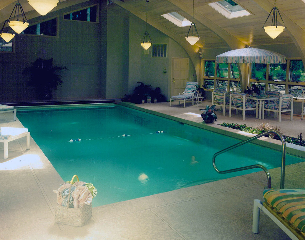 Cette image montre une piscine intérieure traditionnelle rectangle avec des pavés en pierre naturelle.