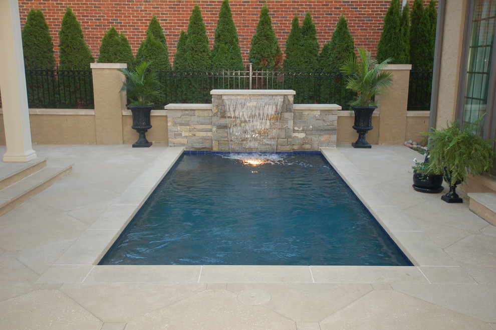 Ispirazione per una piccola piscina monocorsia stile americano rettangolare in cortile con fontane e pavimentazioni in cemento