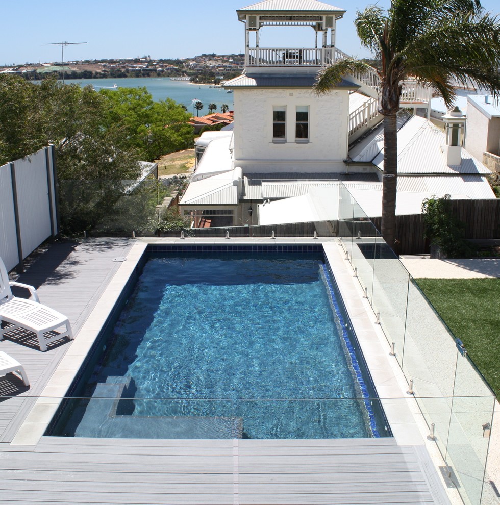 Ejemplo de piscina moderna pequeña rectangular en patio trasero con entablado