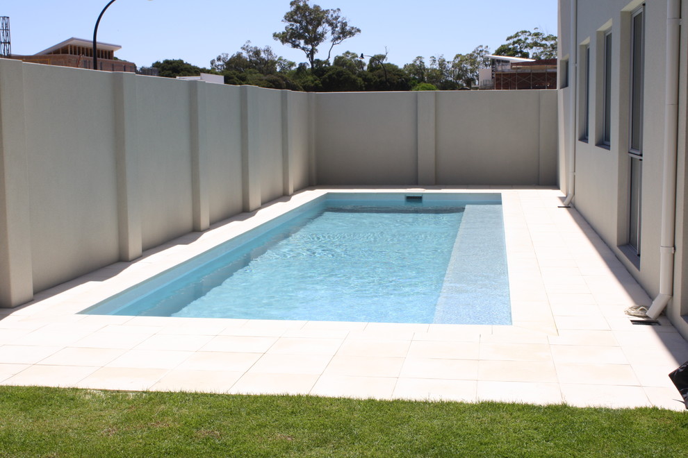 Diseño de piscina minimalista pequeña rectangular en patio trasero con entablado